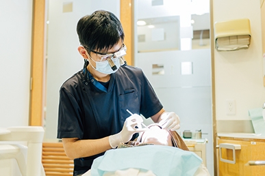 大船みらい歯科の歯科医師が拡大鏡を用いて治療を行っている様子