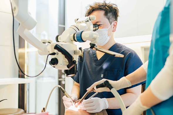 大船みらい歯科の歯科医師がマイクロスコープを使用して治療を行っている様子