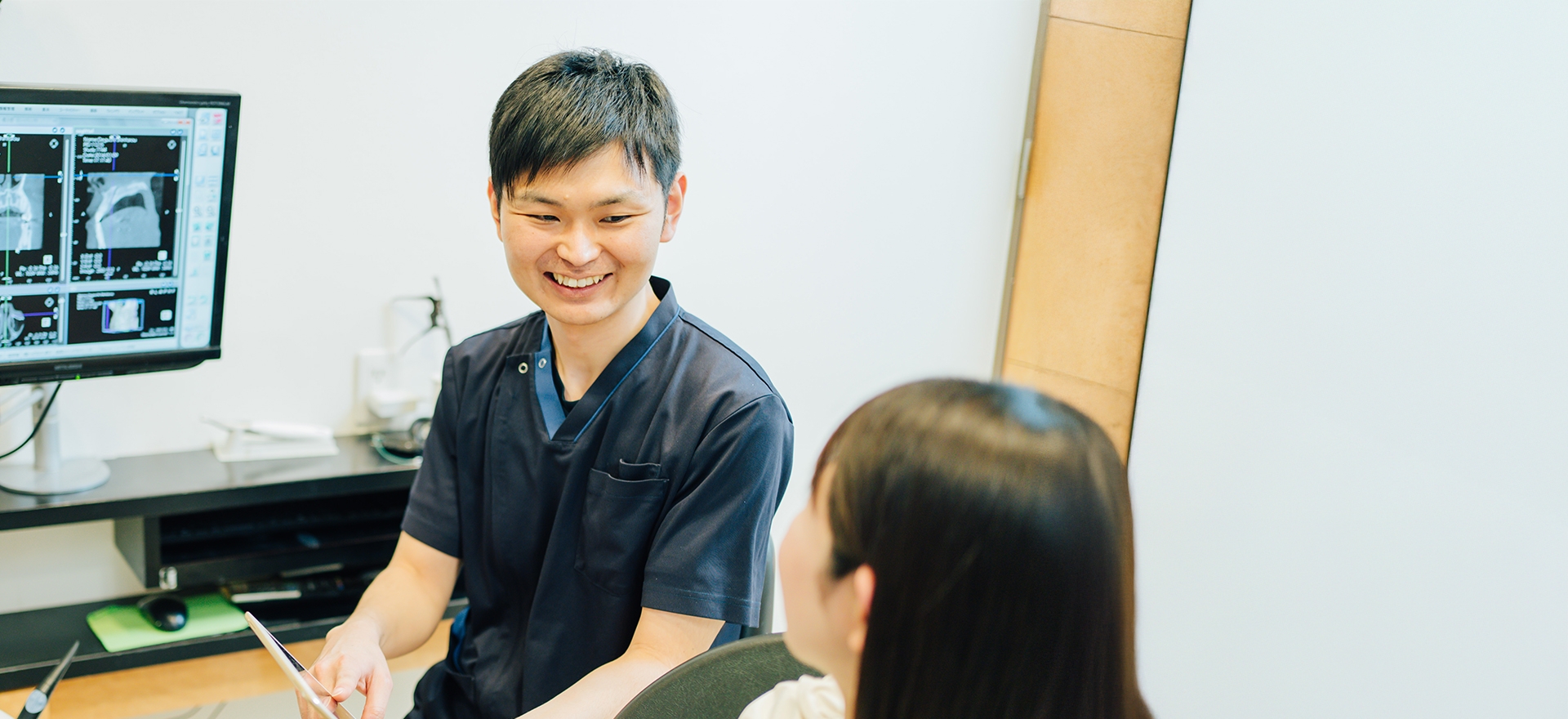 大船みらい歯科の歯科医師が笑顔で説明している様子